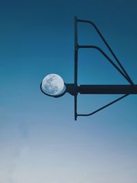 Low angle view of basketball hoop against moon 