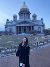 Portrait of young woman standing at temple architecture