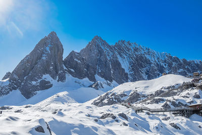 Scenic view of snowcapped mountains against blue sky