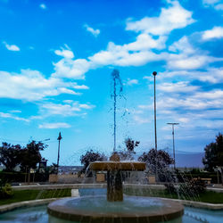 Fountain in park against sky