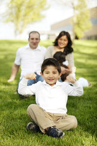 Portrait of happy friends sitting on grass at park