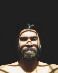 Close-up portrait of woman against black background