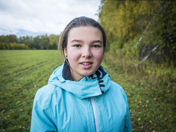 Portrait of smiling girl standing on grassy field