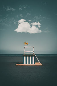 Lifeguard hut at beach against blue sky