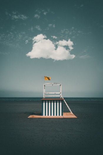 Lifeguard hut at beach against blue sky