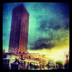 Low angle view of modern building against cloudy sky