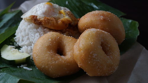 Close-up of donuts and rice on banana leaf