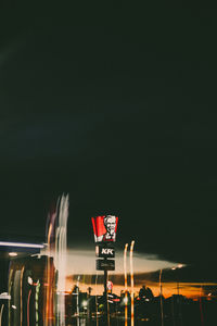 Low angle view of illuminated flags against sky at night