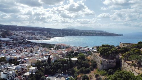 High angle view of townscape by sea against sky