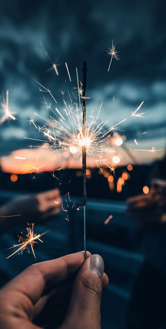 human hand, firework, holding, burning, hand, one person, sparkler, human body part, illuminated, night, celebration, blurred motion, glowing, real people, motion, focus on foreground, event, sparks, firework - man made object, unrecognizable person, firework display, finger, body part, outdoors, dandelion seed