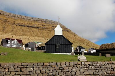 Exterior of houses by building against sky