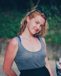 Portrait of smiling young woman standing against trees