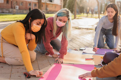 Female friends doing work during protest