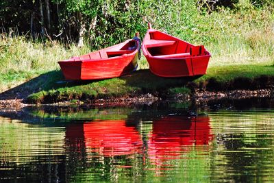 Red boat moored in lake