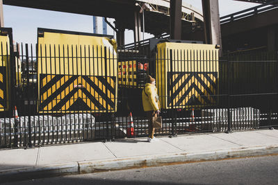 Rear view of man walking on footpath