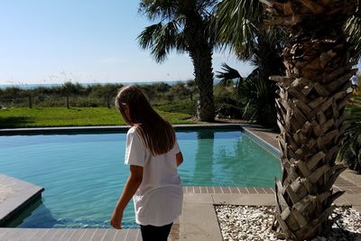 Rear view of woman standing in swimming pool