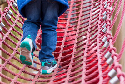 Low section of child climbing on rope bridge