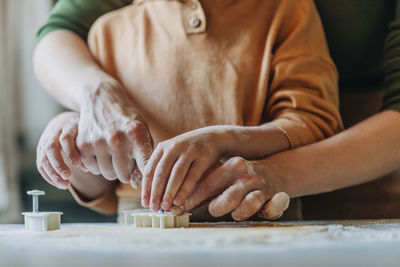 Mother and son preparing gingerbread cookies at home