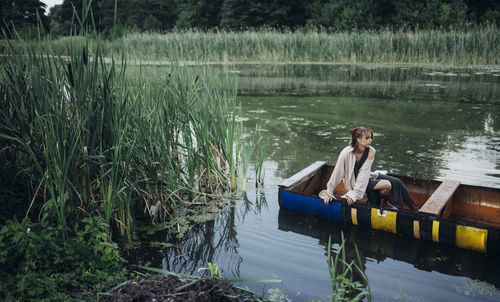 Man sitting in boat on lake