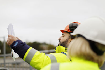 Engineers in reflective clothing discussing plans