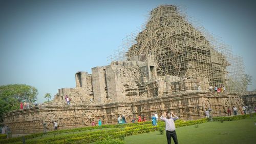 Tourists at historical building against sky