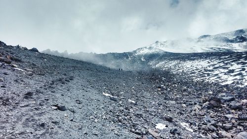 Scenic view of mountains against cloudy sky