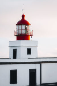 Lighthouse by sea against sky