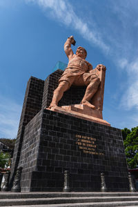 Low angle view of statue against blue sky