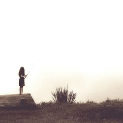 Full length of woman fishing during foggy weather