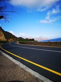 Road by mountain against sky