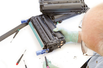 Cropped image of person repairing machinery at table