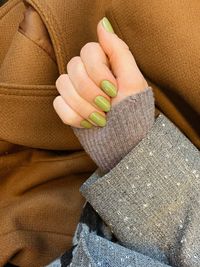 Cropped hand of woman with green nail polish