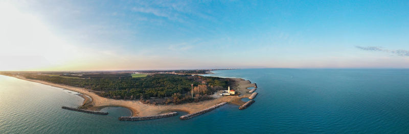 Bibione lighthouse from above at sunset in a panoramic aerial view	with sea and blue sky