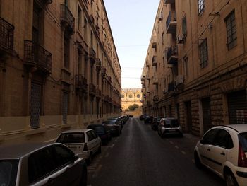 Cars parked on street in front of buildings against sky