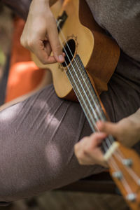 Cropped hands playing the ukulele
