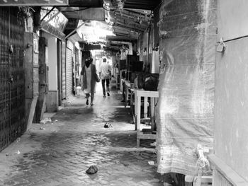 Man walking in alley amidst buildings