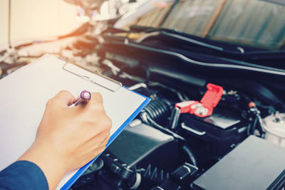 Cropped hands of mechanic repairing car in garage