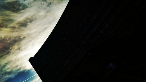 Low angle view of modern building against cloudy sky