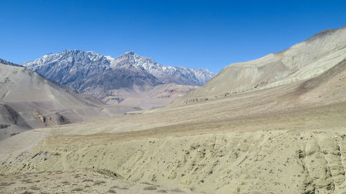 Scenic view of snowcapped mountains against clear blue sky