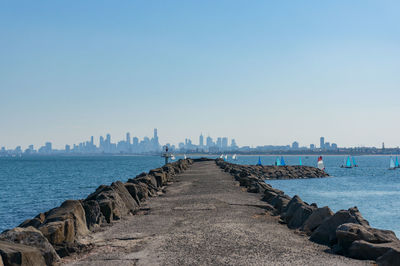 Long pier, jetty with sailing boats and modern cityscape on the background, brighton, melbourne