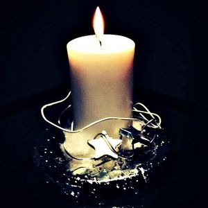 Close-up of lit candle in dark room