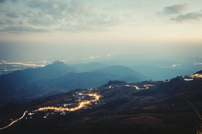 Aerial view of illuminated mountains against sky
