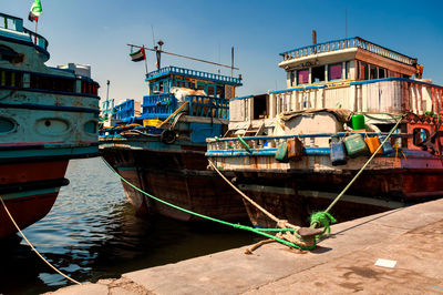 Boats moored in water against sky