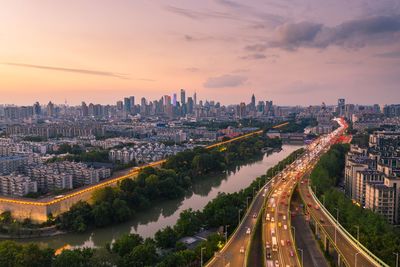 High angle view of road amidst buildings against sky during sunset