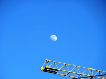 Low angle view of moon against clear blue sky