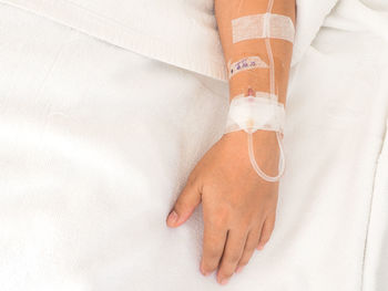 High angle view of human hand on bed