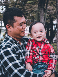 Portrait of father and son with daughter outdoors