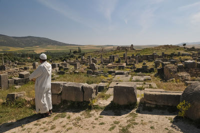 Rear view of man standing against built structure