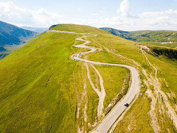 Winding road from high mountain pass, in summer time. aerial view by drone. romania