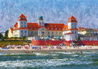 People on beach by buildings against sky